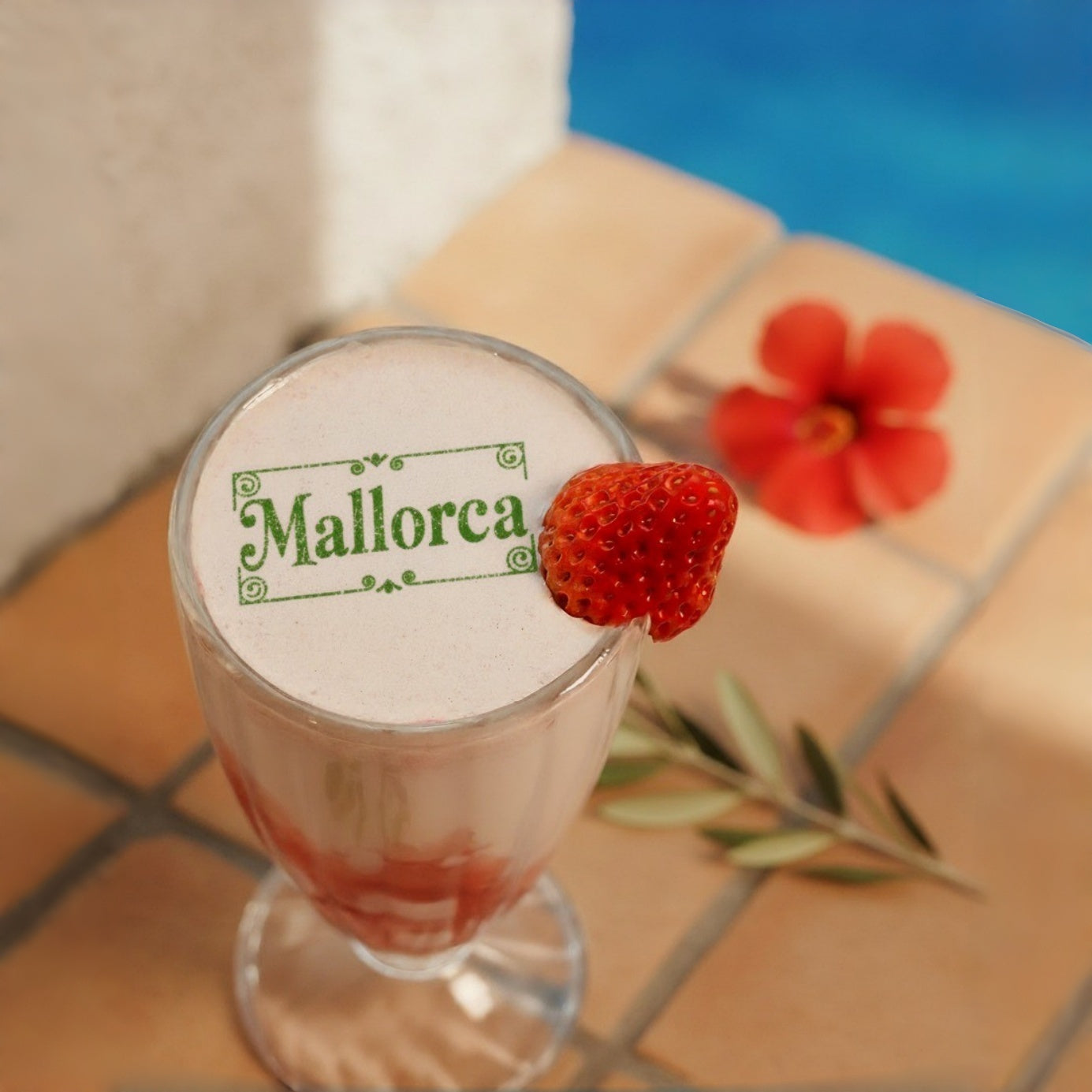 PrintPenで可食性インク印刷した「Mallorca」の文字が乗ったドリンク。ストロベリーと花で飾られ、プールサイドのテラコッタタイル上に置かれている。
