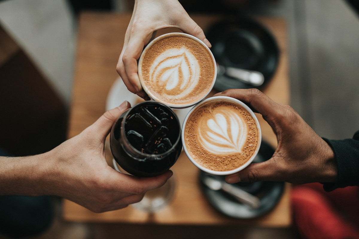 コーヒーカップを手にした3人。コーヒーにはラテアートが施されています。