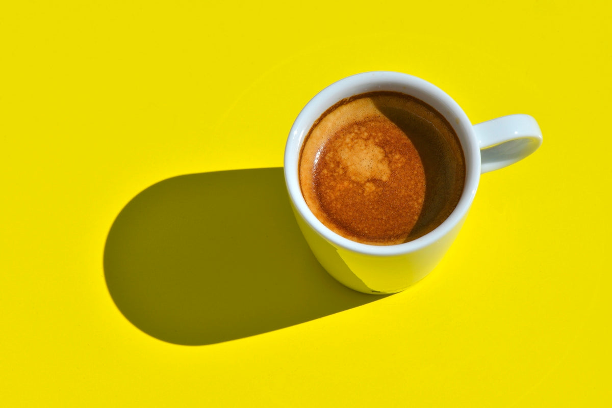 茶色いコーヒーが入った白い陶器のマグカップ