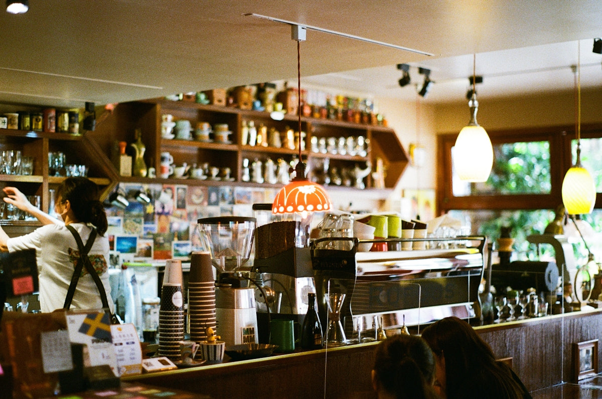 a woman behind the counter of a coffee shop
