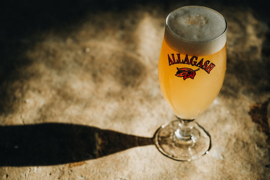 a glass of beer sitting on top of a table