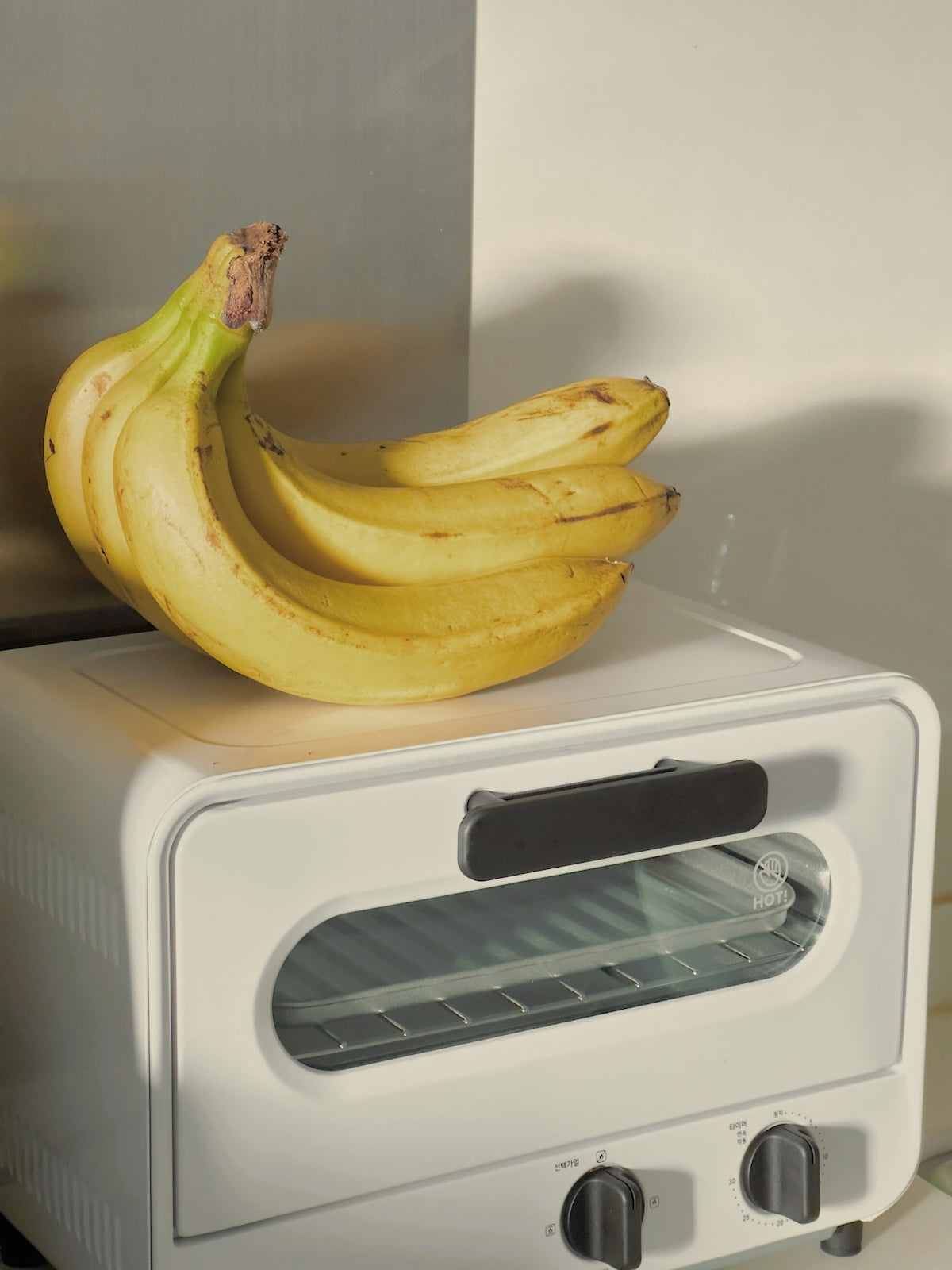a bunch of bananas sitting on top of a toaster oven